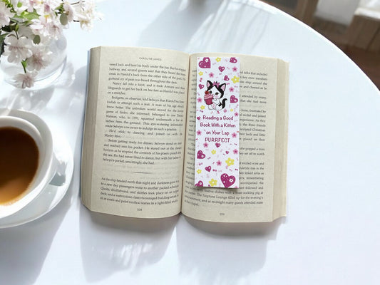 Cute kitten bookmark in use - marking a page in an open book"
