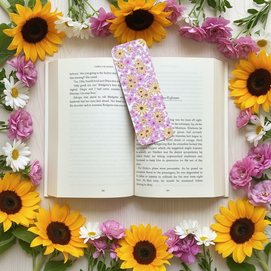 Open book with a floral bookmark surrounded by sunflowers and other flowers on a light background