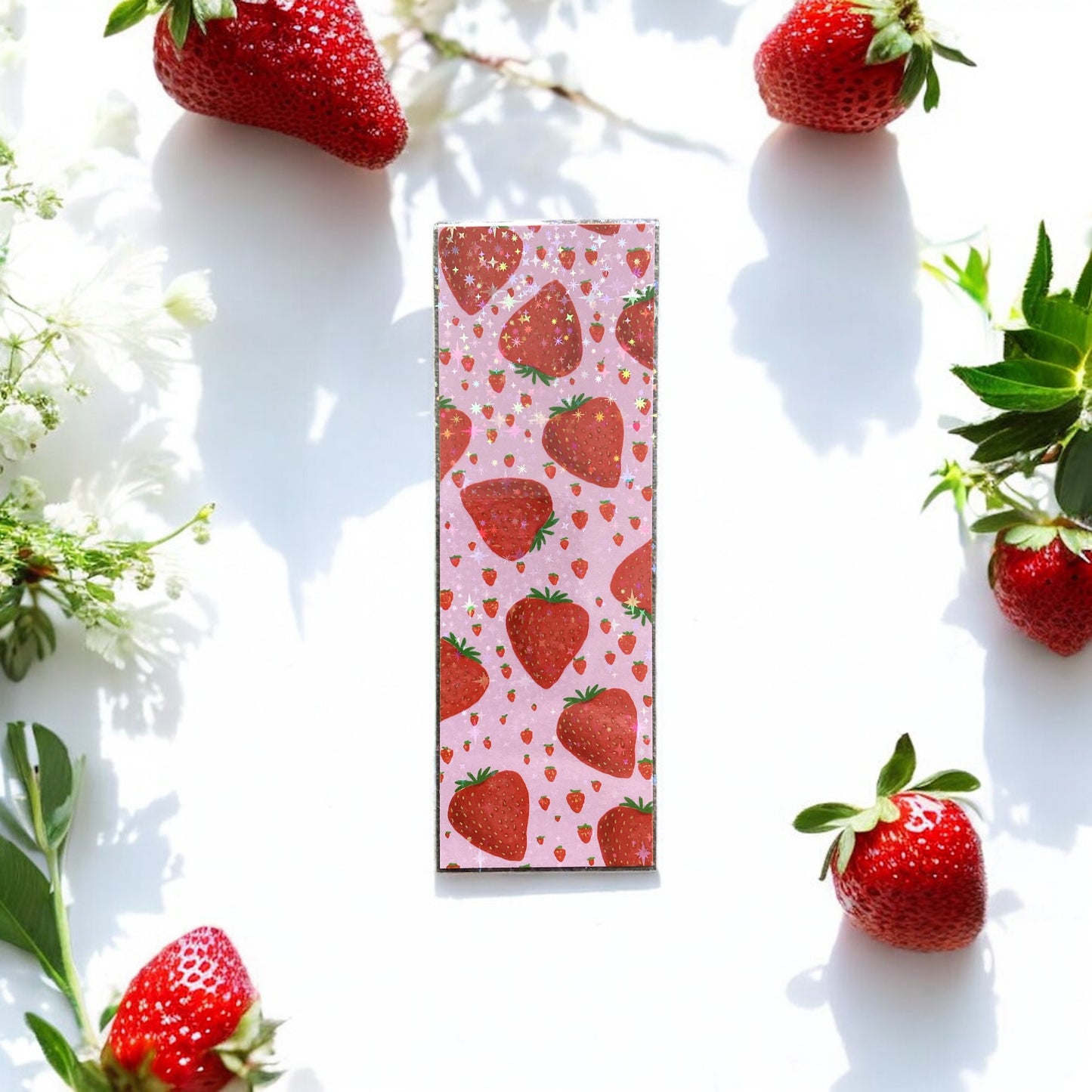 Bookmark with strawberry pattern surrounded by strawberries and green leaves on a white background