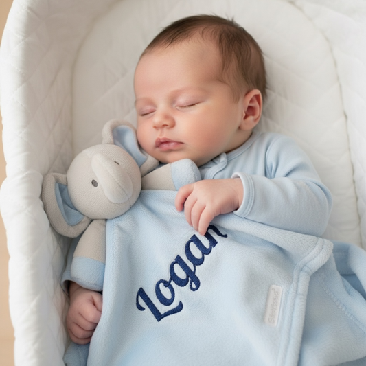 Newborn baby sleeping in a crib with a blue blanket and Elephant toy