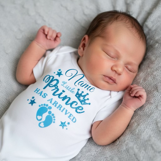 Newborn baby wearing a ves with blue text Little Prince has arrived