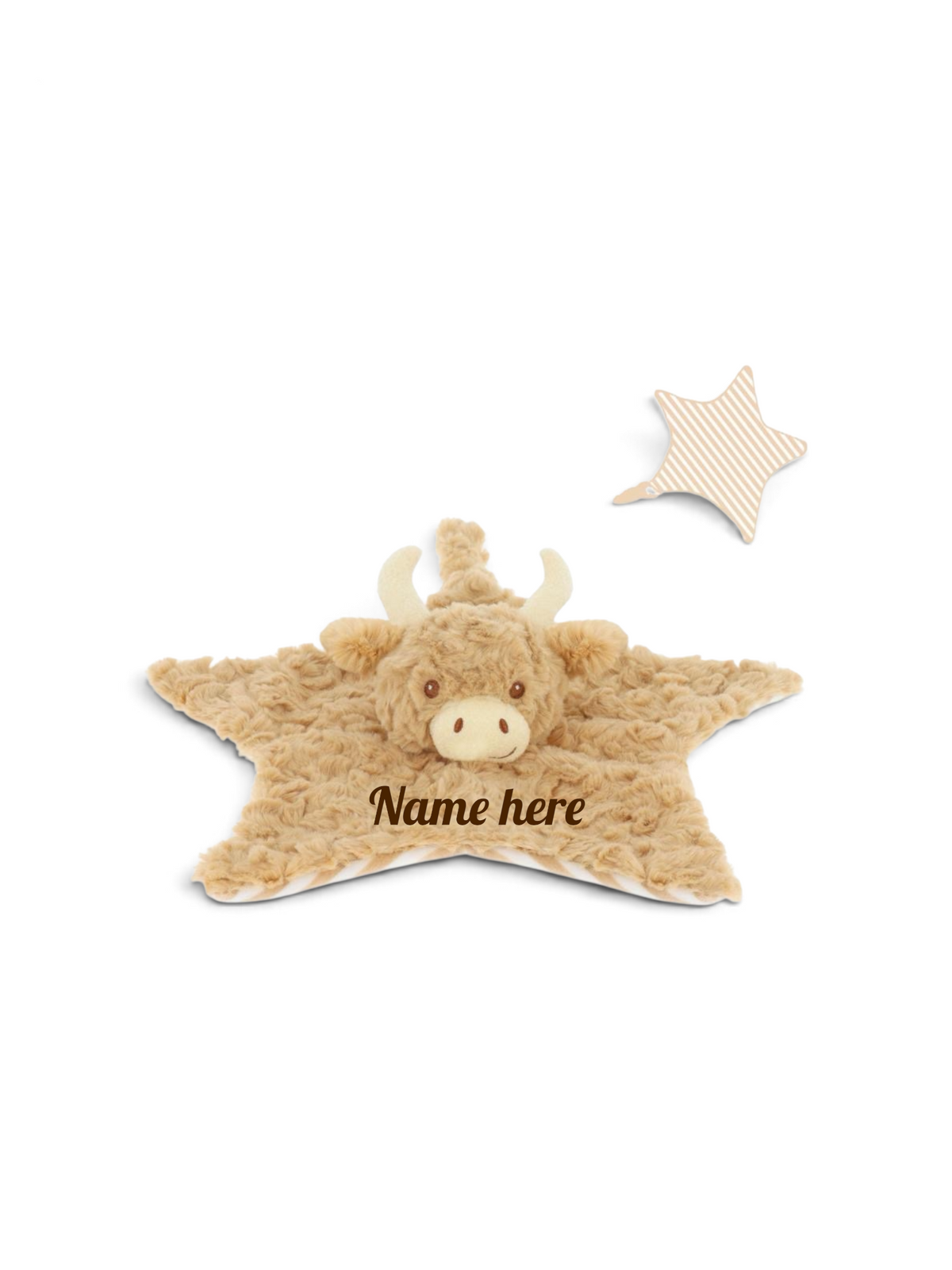 A Highland cow plush baby comforter featuring a fluffy tan cow face with cream horns and nose, with the text 'Name here' printed on the front. A small matching star-shaped tag with a beige and cream striped pattern is shown in the upper right.